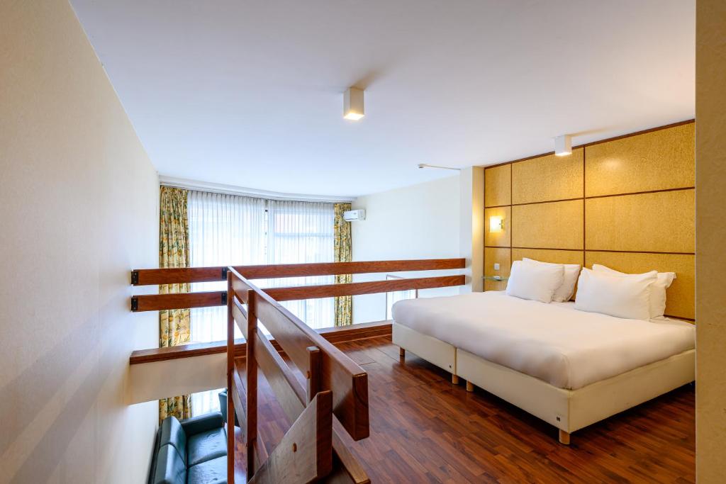 sypialnia z białym łóżkiem i schodami w obiekcie B-aparthotel Montgomery w Brukseli
