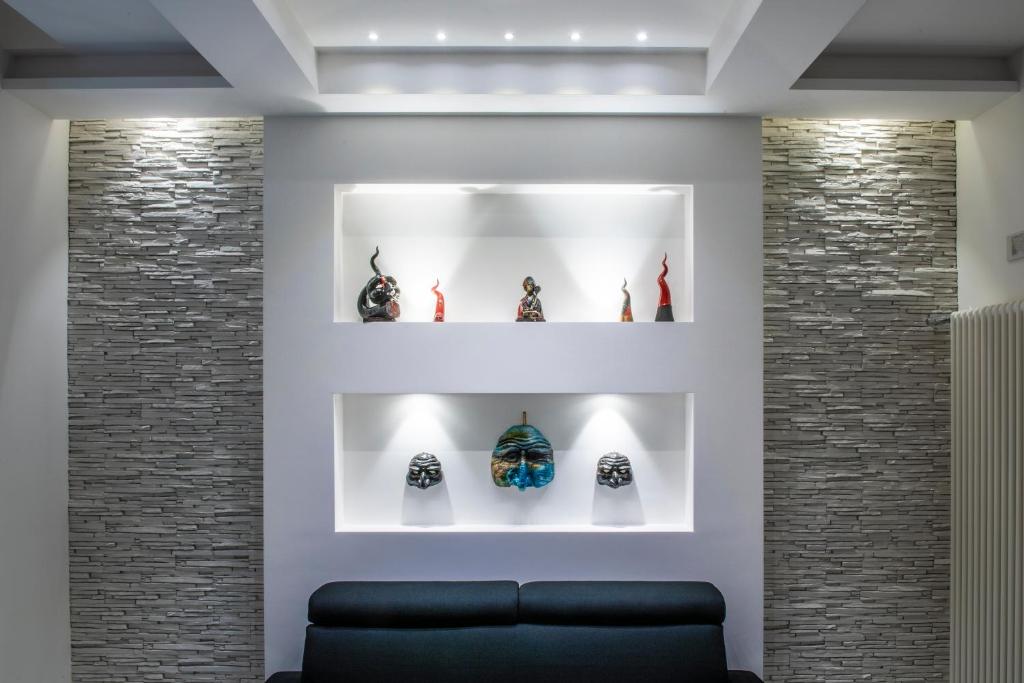Habitación con sofá y estanterías con jarrones en Rettifilo 201 Exclusive Rooms en Nápoles