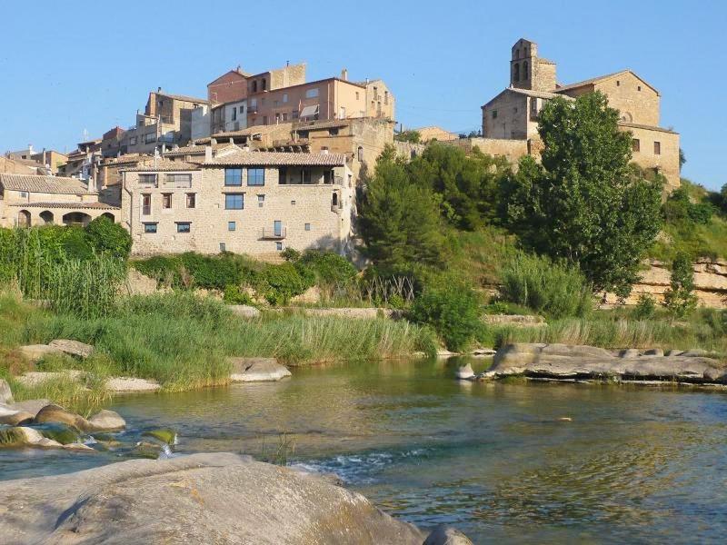 a group of buildings on a hill next to a river at CASA ARENS in Arens de Lledó