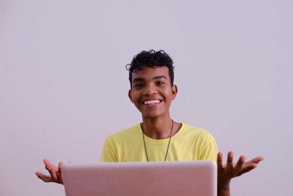 a young man is smiling while holding a laptop computer at Casa Tunido in Santa Marta