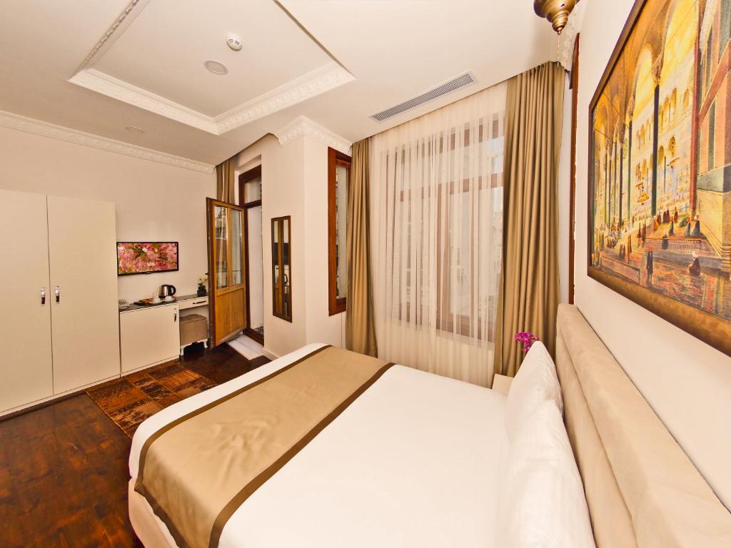 een slaapkamer met een bed en een schilderij aan de muur bij Nusretbey Hotel in Istanbul