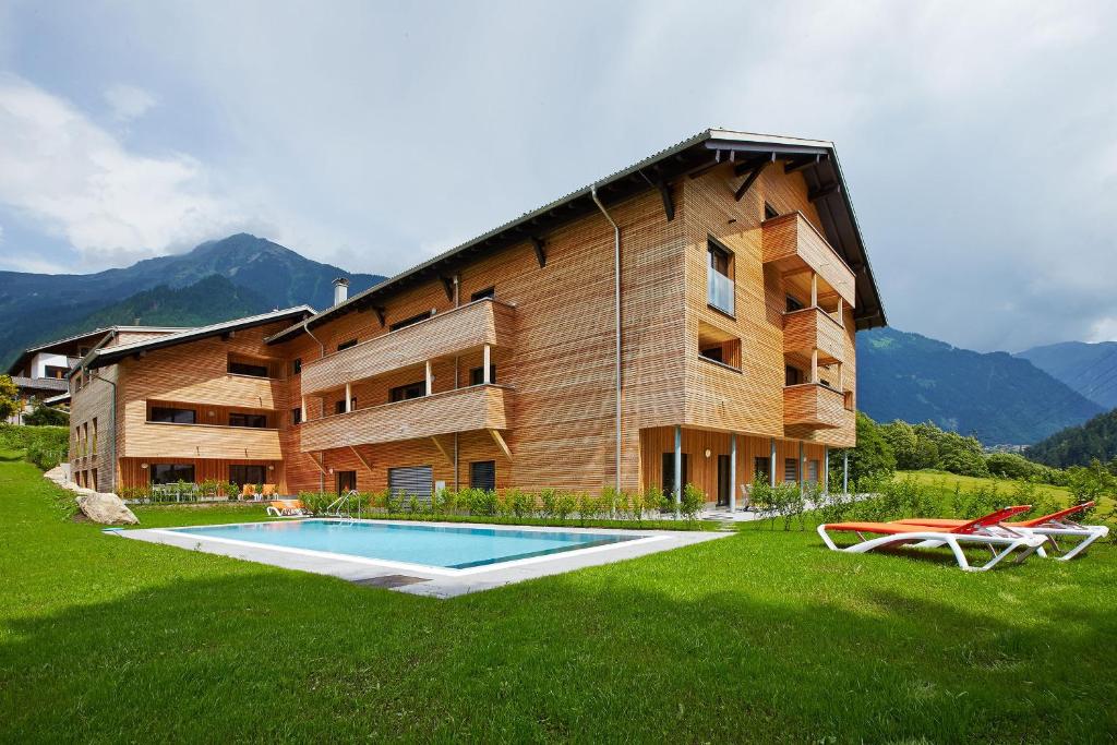 een groot gebouw met een zwembad in het gras bij Appart Gastauer in Sankt Gallenkirch