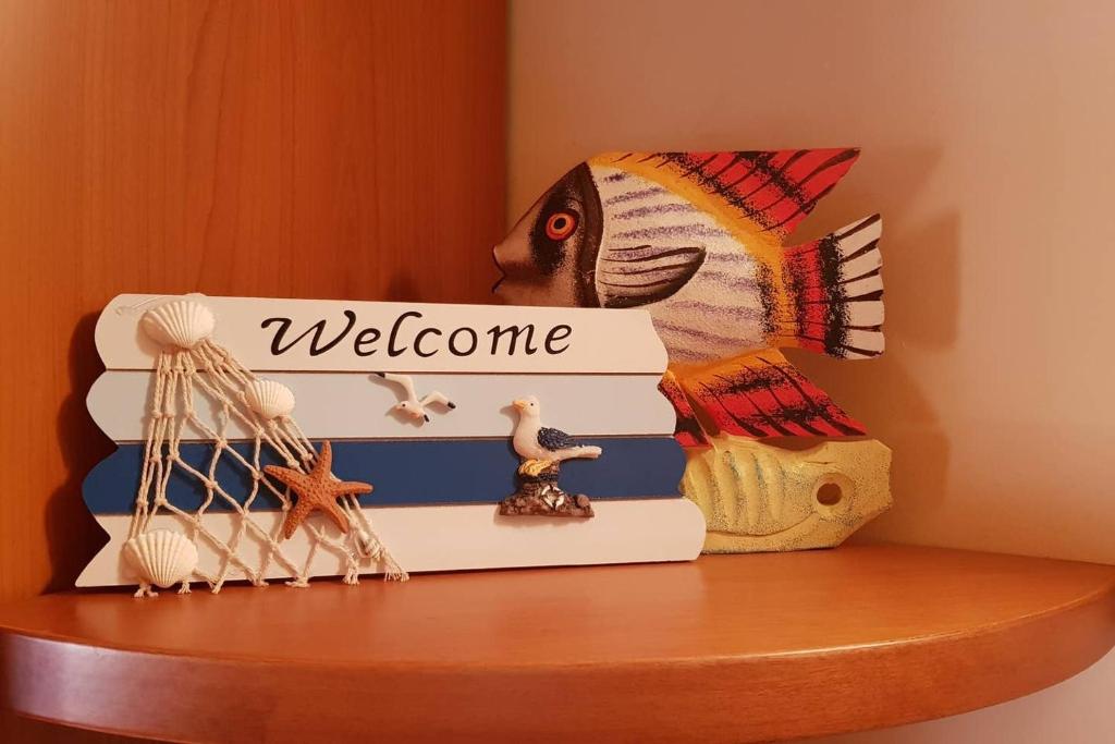 una mensola con un cartello di benvenuto e un pesce sopra di La casa di Ulisse 008055- LT0806 a Sanremo