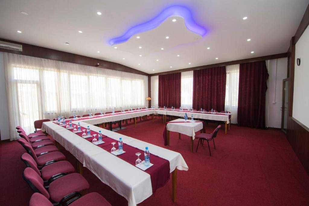 a conference room with tables and chairs and a purple ceiling at Holiday Resort in Velika Slatina