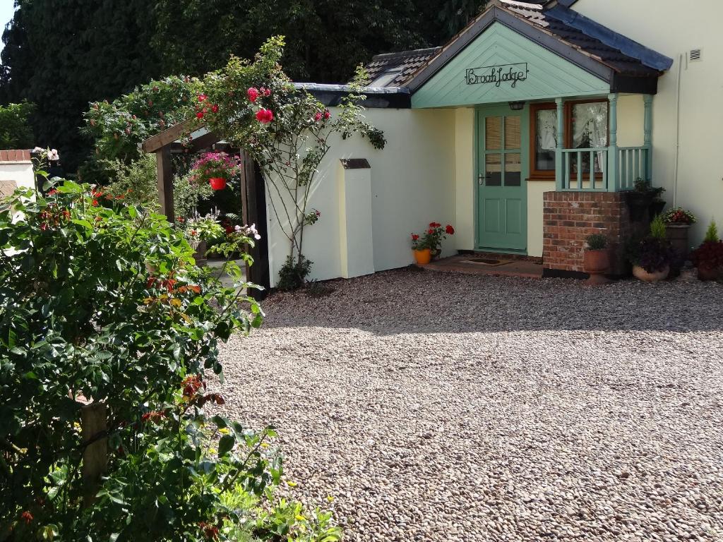 a house with a gravel driveway in front of it at Brook Lodge Country Cottage in Doncaster