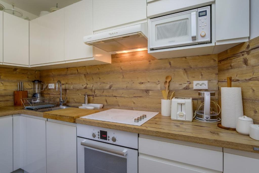 a kitchen with white cabinets and a microwave at Beautiful Apartment Jelena 1 in Veli Lošinj