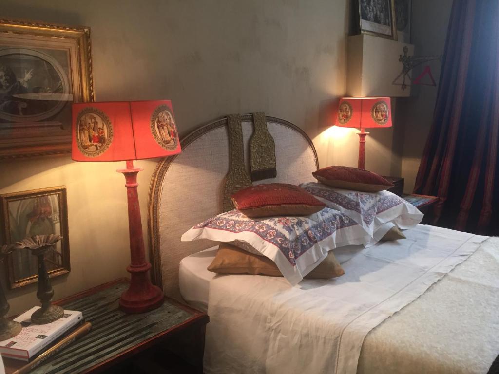 a bed with a pillow on top of it next to a lamp at La Maison Rousseau Chambre d'hôtes in Nîmes