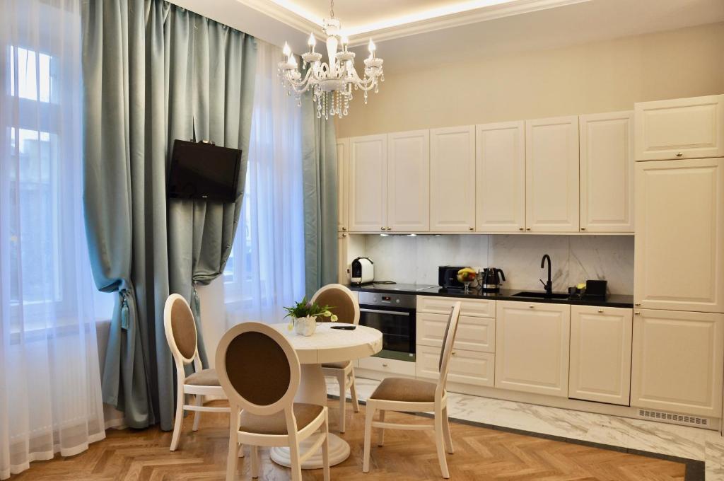 cocina con mesa, sillas y lámpara de araña en Tresor Barska Apartments en Cracovia