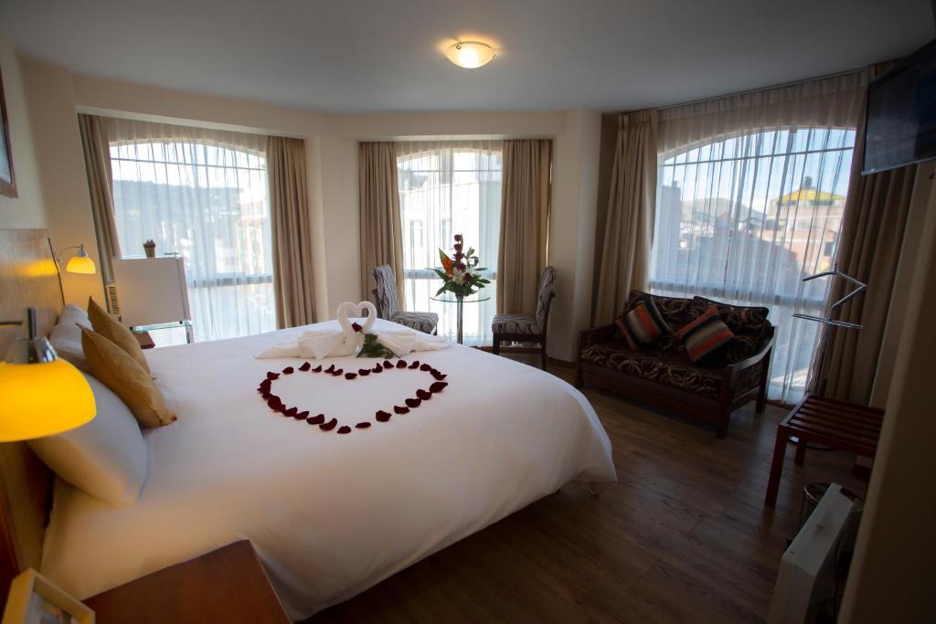 Sol Plaza Hotel في بونو: غرفة فندقية عليها سرير وقلب
