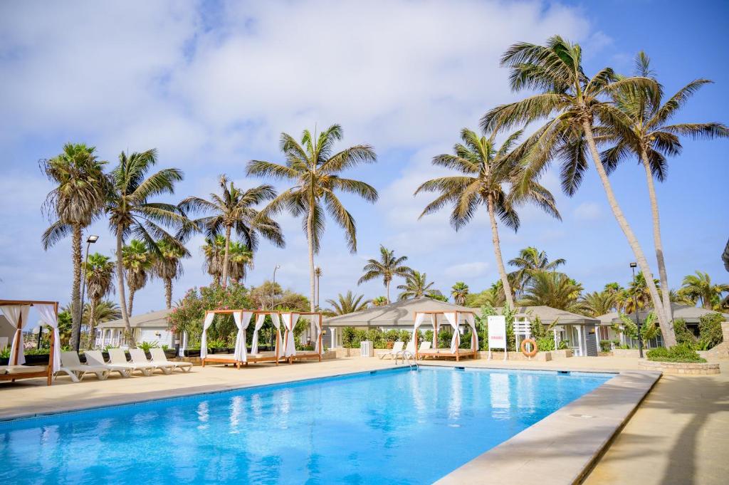 a pool at the resort with palm trees in the background at Oasis Belorizonte in Santa Maria