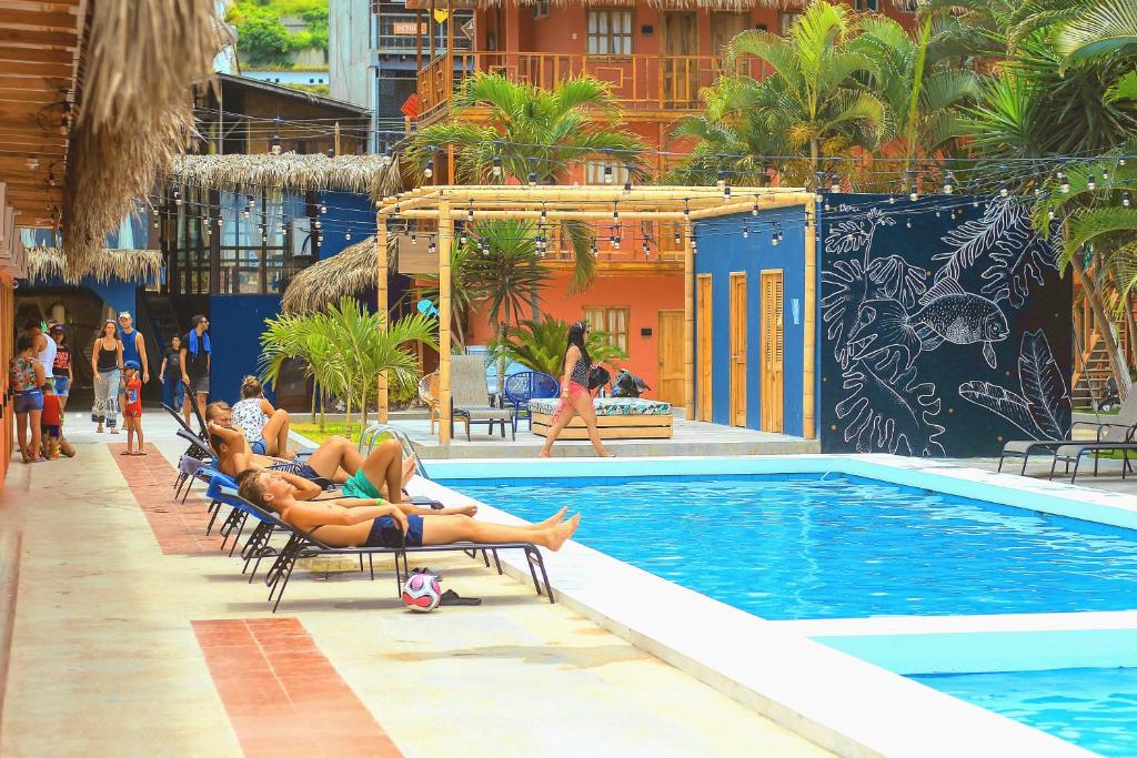 un grupo de personas sobre tumbonas junto a una piscina en Selina Montañita, en Montañita