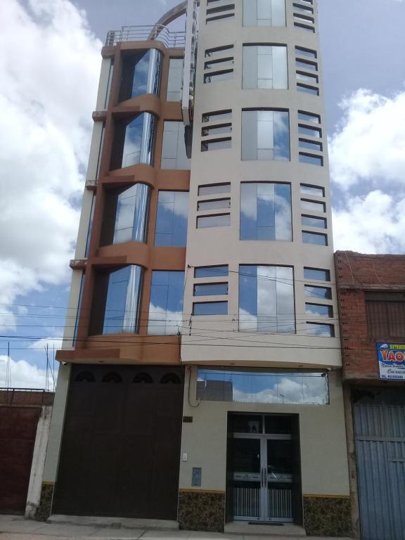 un edificio blanco alto con muchas ventanas en Hotel Suite Juliaca, en Juliaca