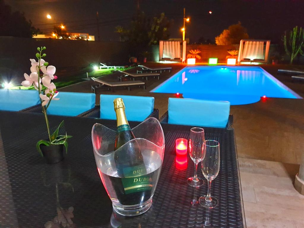 una bottiglia di vino e due bicchieri di vino su un tavolo di Villa Elena a San Jose de sa Talaia
