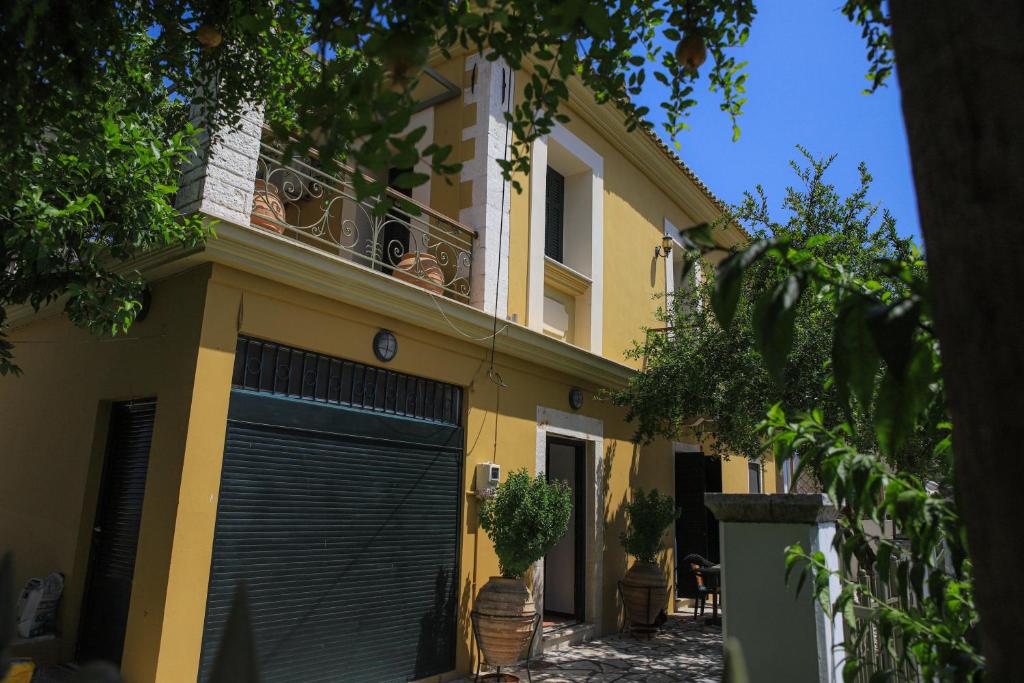 a yellow house with a black garage door at Palairos historic property in Paleros