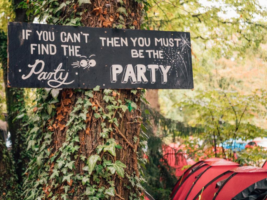 a sign on the side of a tree with ivy at Oktoberfest and Springfest Inclusive Camping in Munich