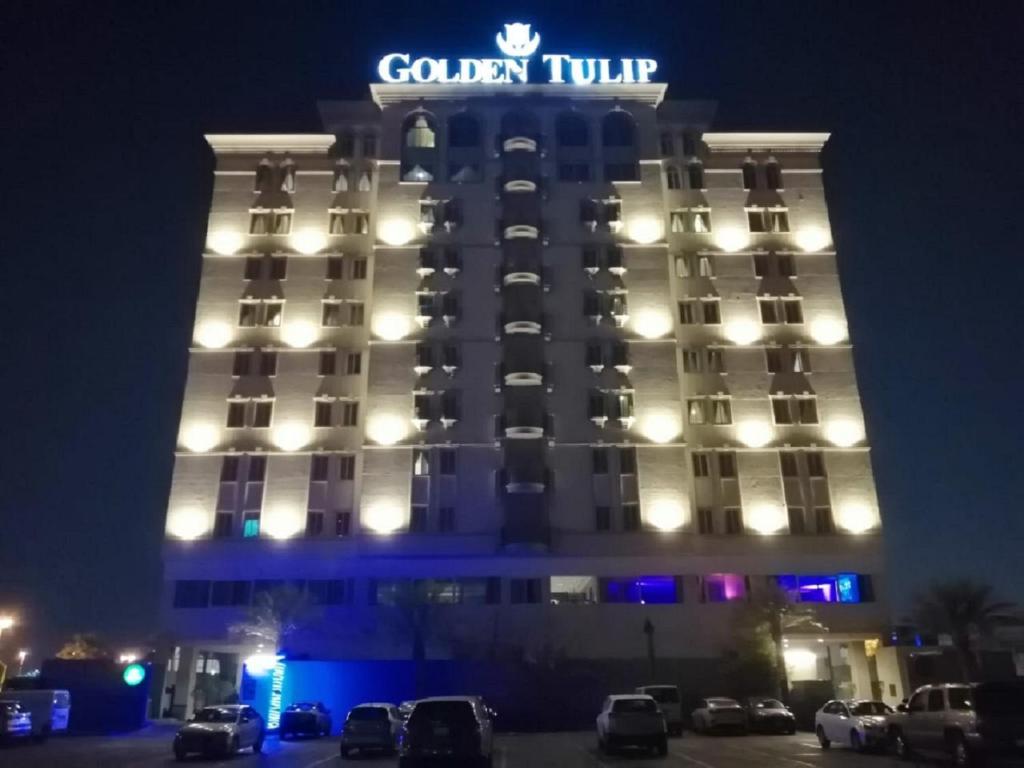 a hotel with a sign on top of it at night at Golden Tulip Al Khobar in Al Khobar