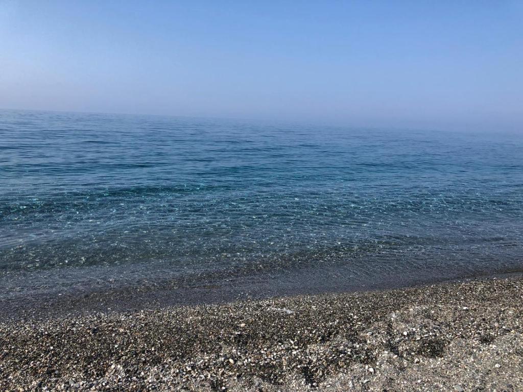 a rocky beach with the ocean in the background at Appartamento in Residence Mareblu in Nocera Terinese
