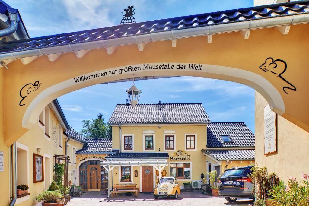 an archway over a street with a building at Hotel Am Eifelsteig in Neroth