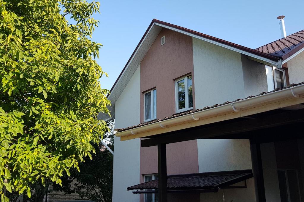 GoraTwins guest house near Boryspil airport في Hora: منزل أمامه شجرة