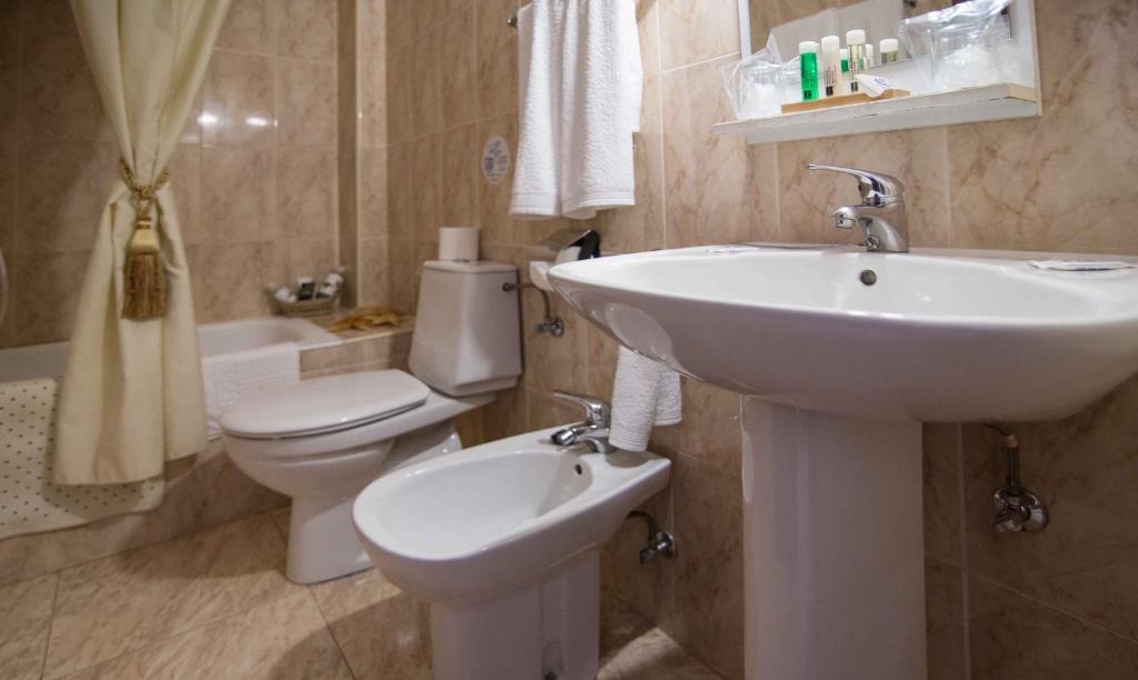 łazienka z białą umywalką i toaletą w obiekcie Hostal Alba Taruta w mieście Guadalupe