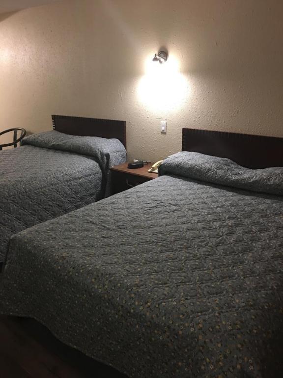 Postel nebo postele na pokoji v ubytování Red Deer Inn & Suites