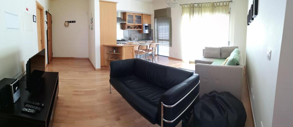 a living room with a couch and a kitchen at Flat Sines in Sines