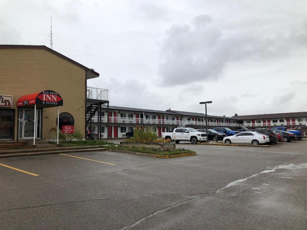 un estacionamiento con autos estacionados frente a un edificio en Red Deer Inn & Suites en Red Deer