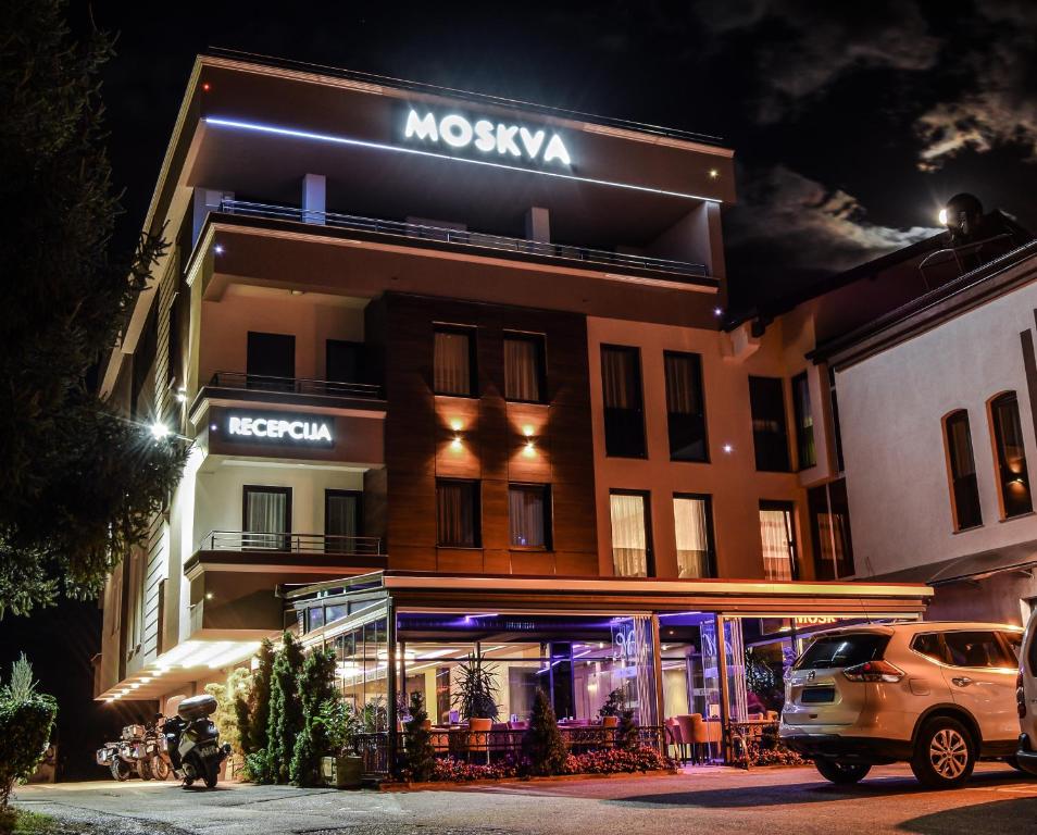 a building with a car parked in front of it at Hotel Moskva in Banja Luka
