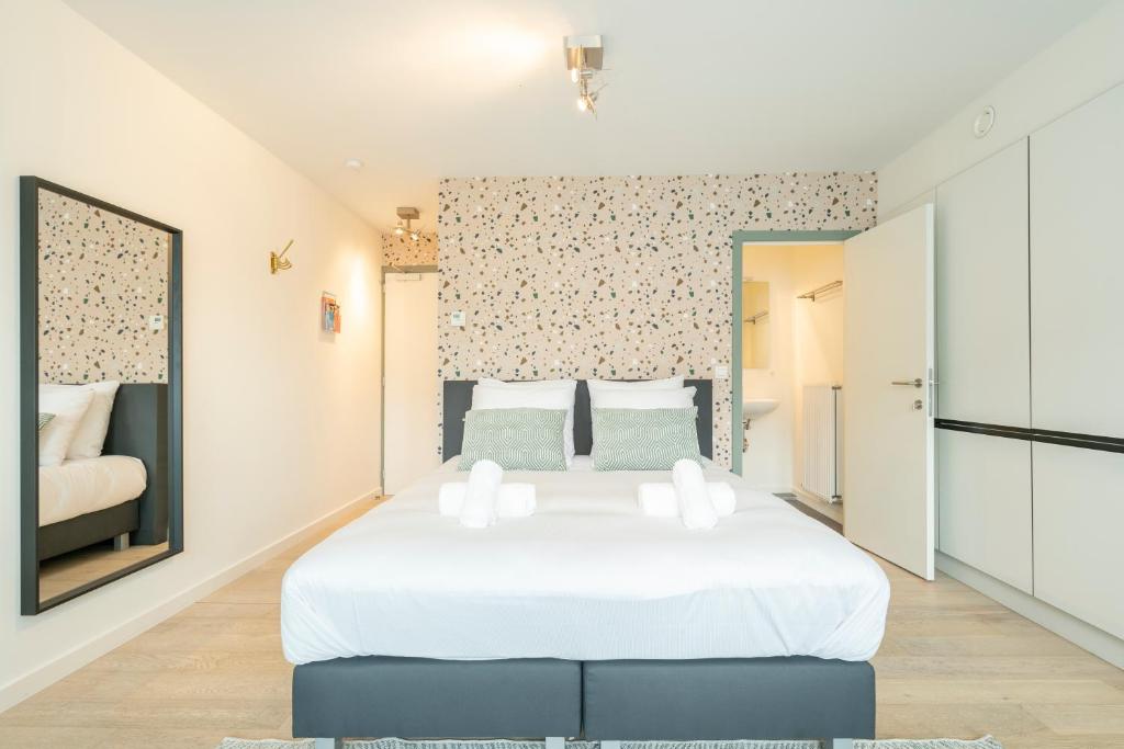 1 dormitorio con 1 cama blanca grande en una habitación en The Card Room Green Studio en Amberes