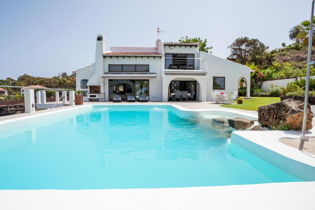 a large swimming pool in front of a house at Casa Las Rocas in Santa Úrsula