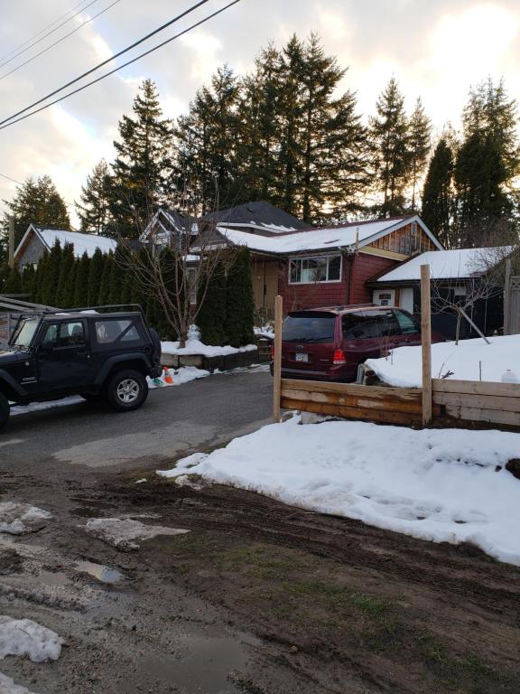 a car parked in front of a house in the snow at Surrey chic 2 bdrm basement unit in Surrey