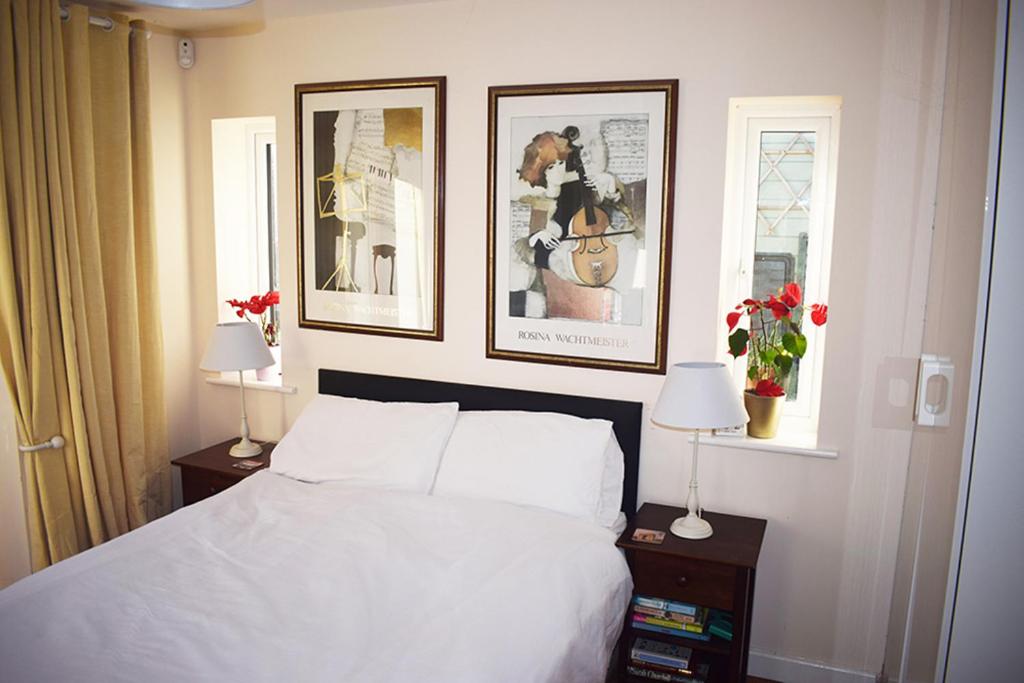 a bedroom with a bed and three pictures on the wall at Wings in Oakham