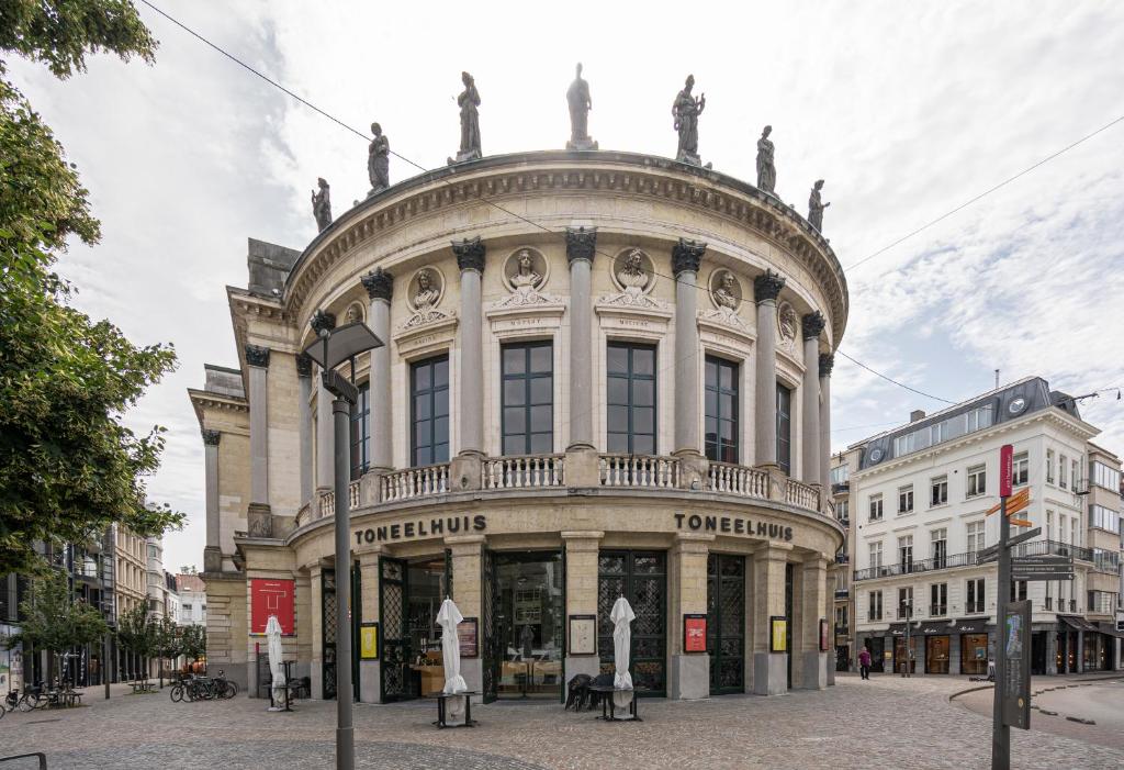 un grande edificio con statue sopra di esso di SHWAY - The India Yellow Studio ad Anversa