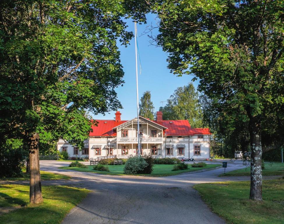 a large white house with a red roof at Borrgården Hostel in Ljusdal