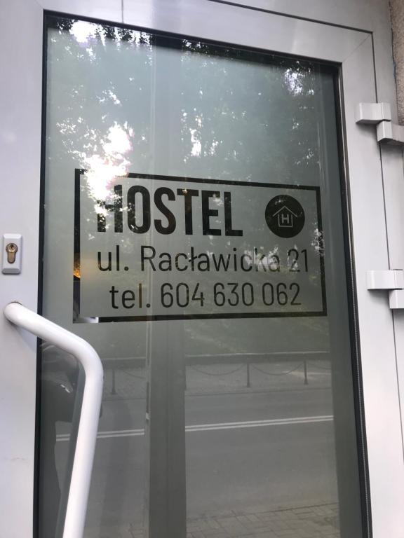 a sign on the door of a building with a hostel sign on it at Piwnica in Miechów