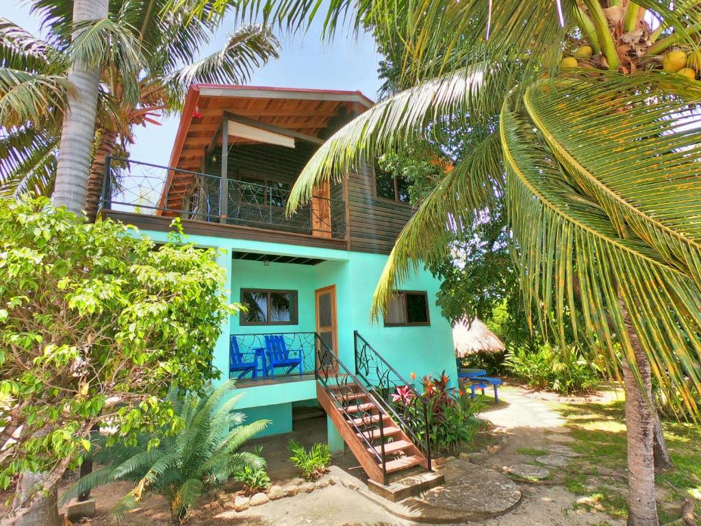 a blue house with a staircase in front of it at Captain Jak's Rentals in Placencia Village