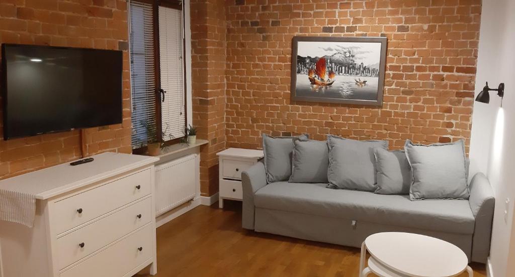 a living room with a couch and a flat screen tv at Apartament Uroczy Zakątek in Gliwice