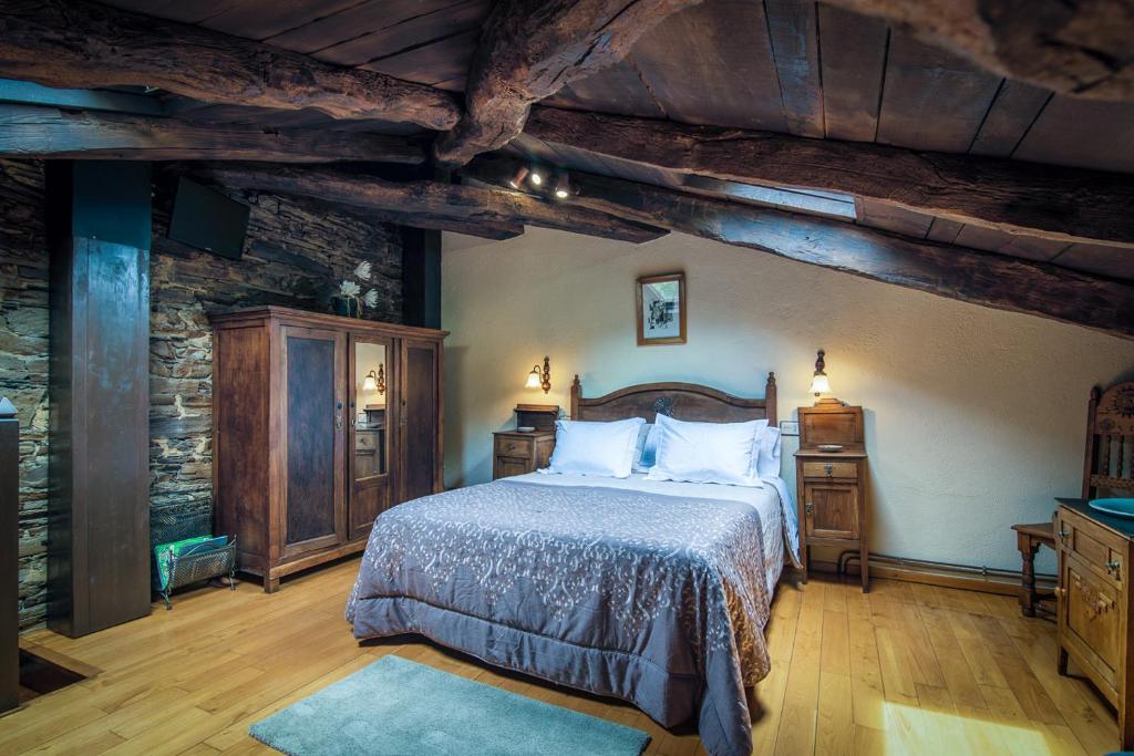 サンタ・エウラリア・デ・オスコスにあるApartamentos Rurales Casa Riverasの木製の天井の客室で、ベッドルーム1室(ベッド1台付)