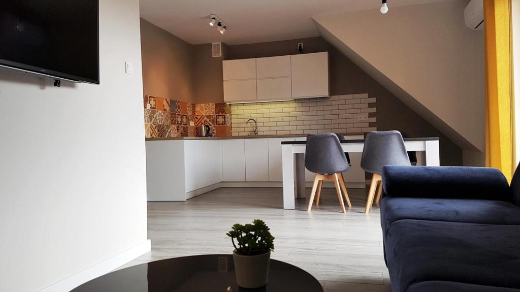 a kitchen and living room with a table and chairs at Szczawnica Apartament C6 in Szczawnica