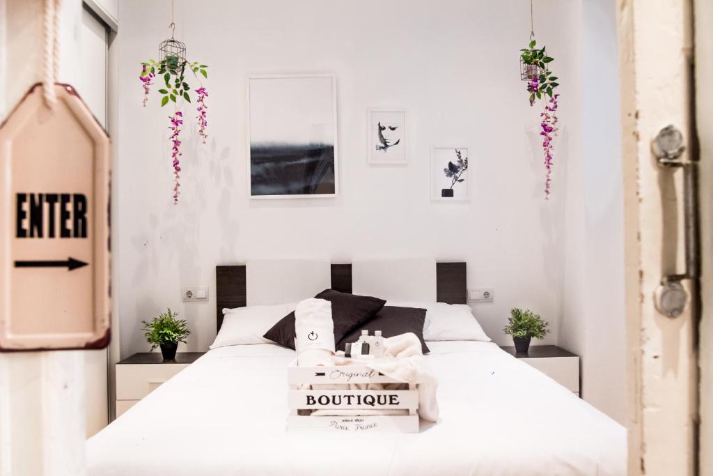 a white bedroom with a bed with a box on it at Ruzafa Apartment in Valencia