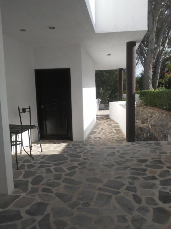 un pasillo con una mesa y una puerta negra en Casa de Cactus en Bernal