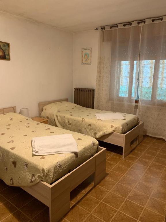 una camera da letto con due letti e una finestra di Camere Solidea a Veronella