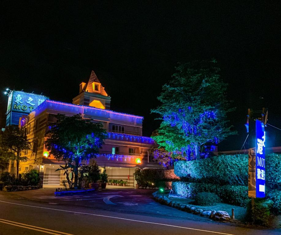 um edifício com luzes azuis à noite em Dong Zhi Gang Motel em Donggang