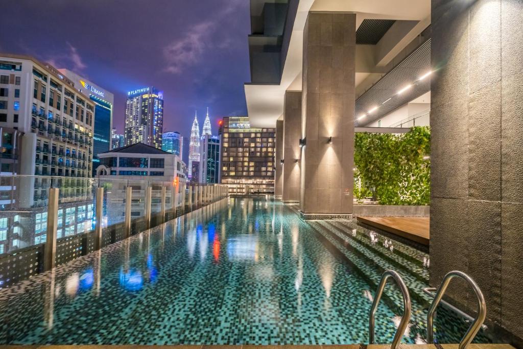 a pool on the roof of a building with a city skyline at Anggun Residences Serviced Suites in Kuala Lumpur