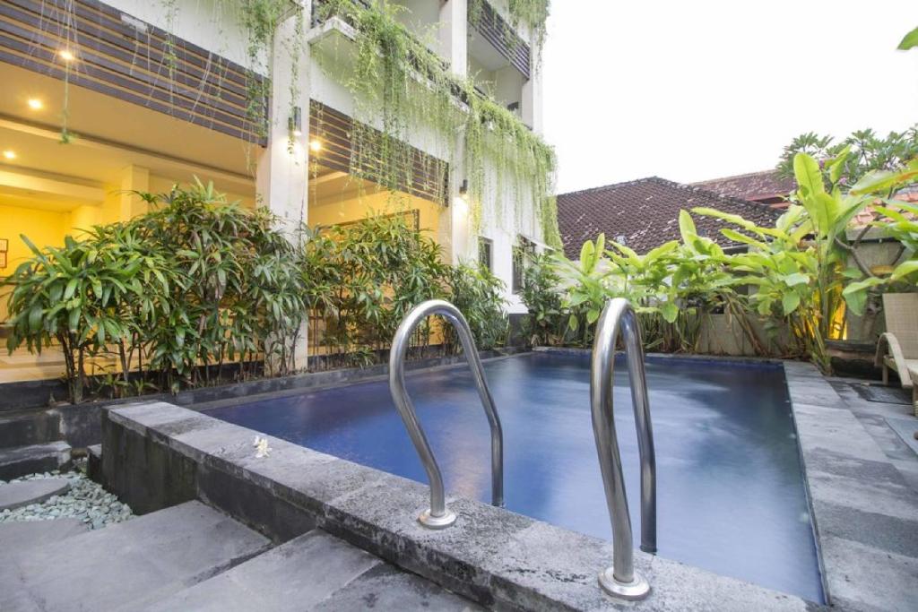 a swimming pool in front of a building at RedDoorz at Benesari 2 Legian in Kuta