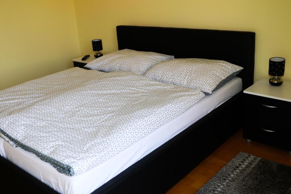 a bedroom with a large bed with white sheets and pillows at Apartman Klara in Karlovac