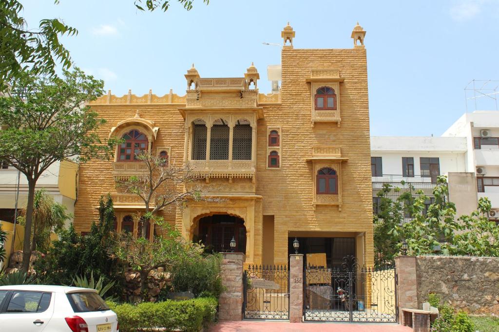 an old house with a car parked in front of it at Jaisal Castle Homestay in Jaipur