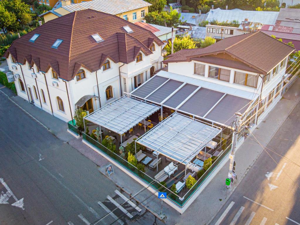 une vue sur un grand bâtiment blanc avec un toit dans l'établissement Hotel Eden, à Râmnicu Sărat