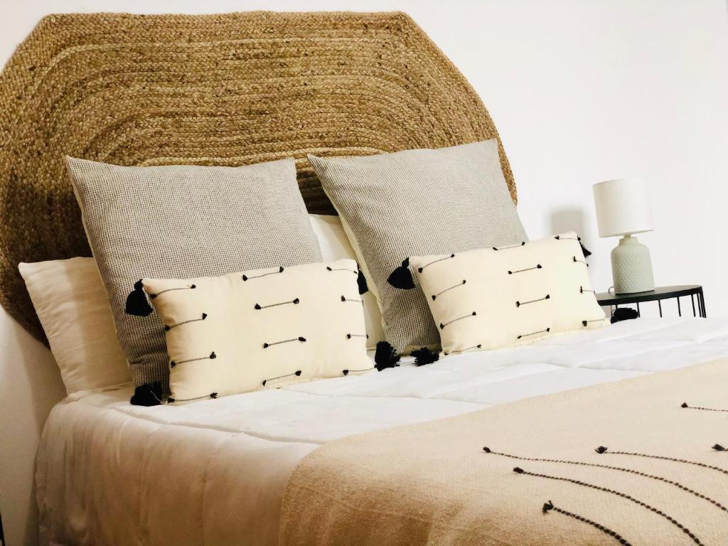 una camera da letto con un grande letto con lenzuola e cuscini bianchi di Canaryislandshost l Surf Lanzarote a Famara