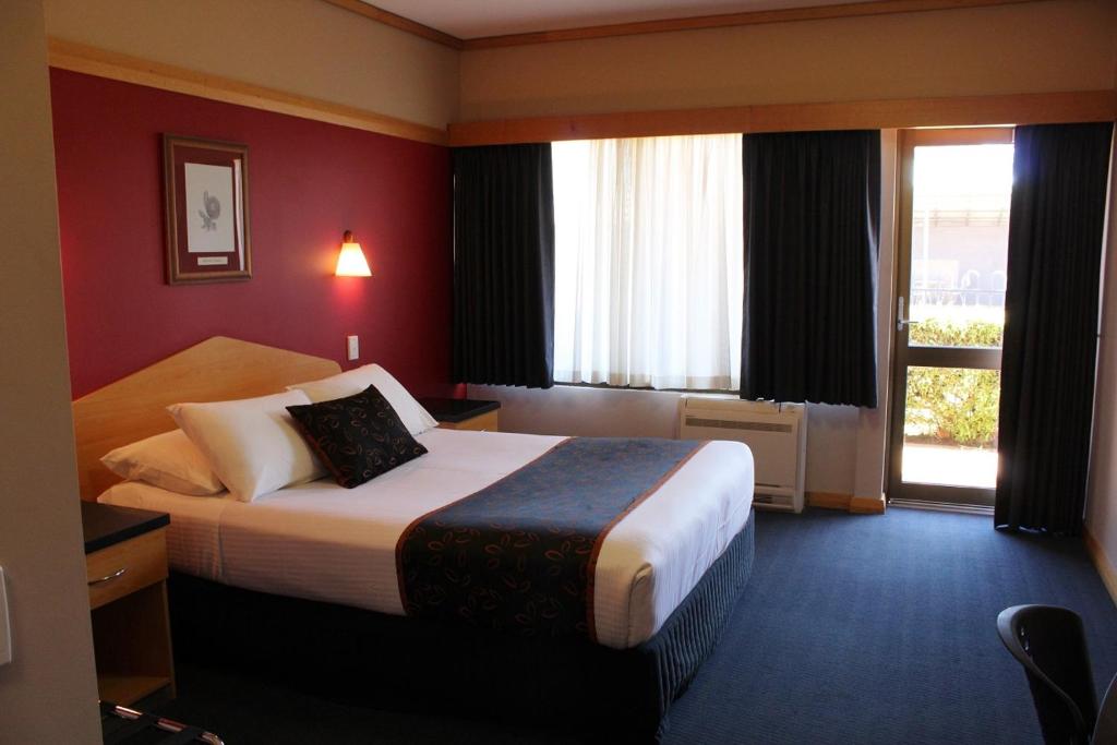 a hotel room with a bed and a window at Banksia Motel in Collie